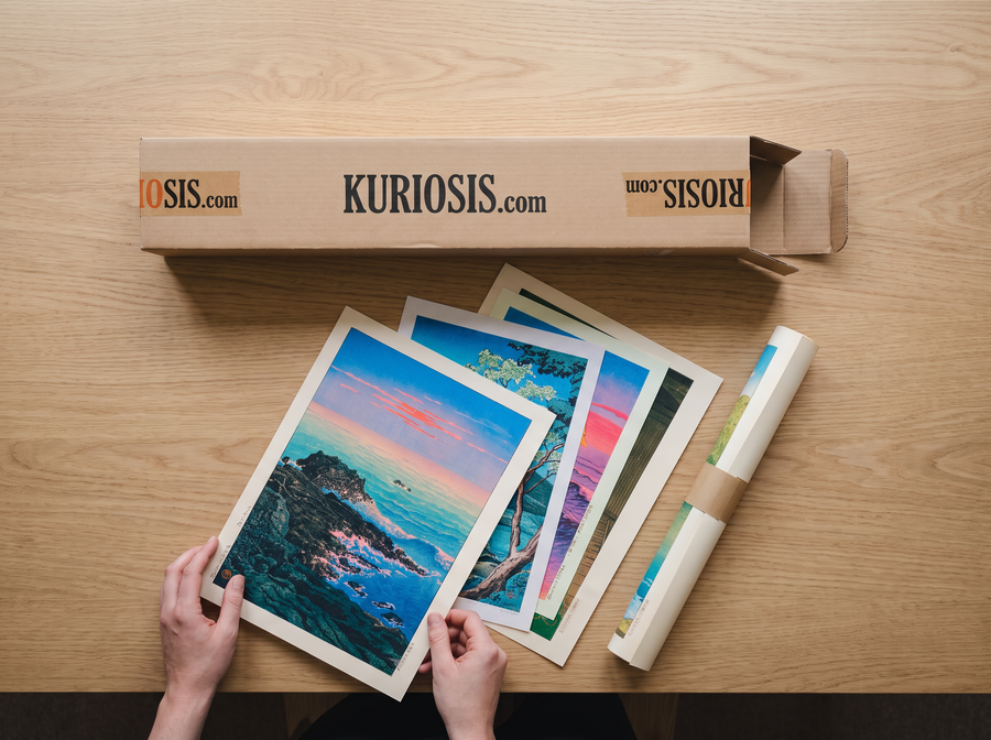 Kuriosis Mystery Box opened on a table with posters fanning out